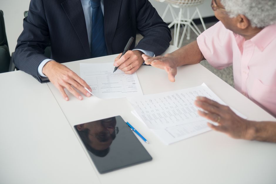 Older client reviewing insurance documents with an advisor
